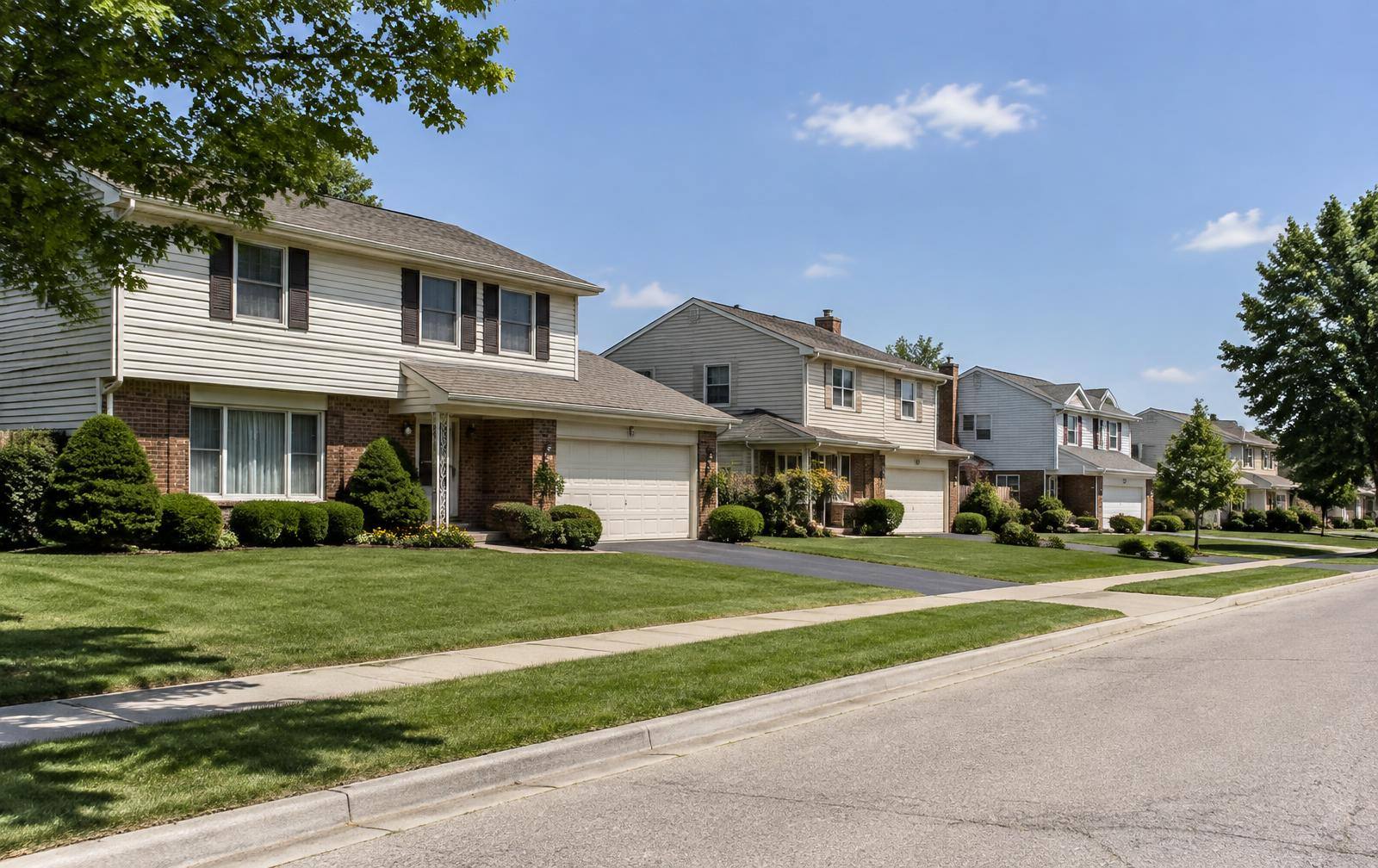 Two-story homes with attached garages along a wide street